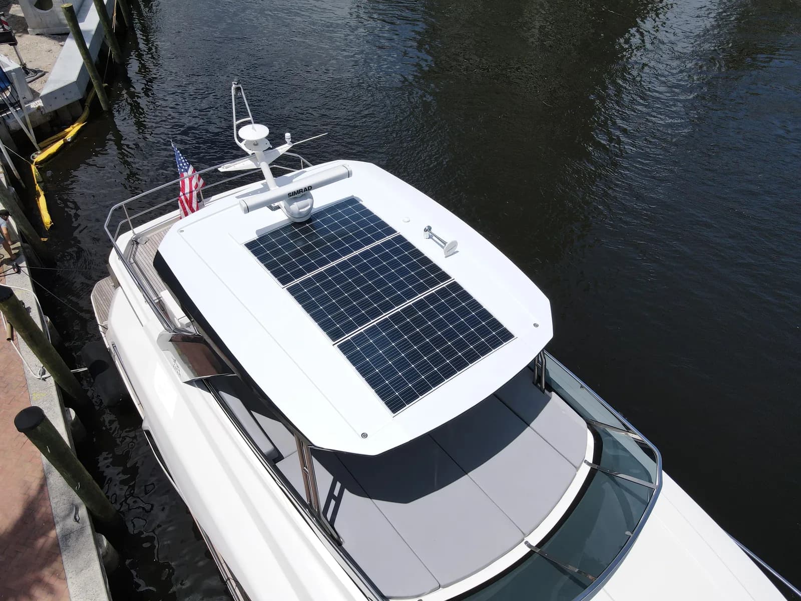 The same yacht hardtop after refinishing — clean uniform white film, solar array and radar mount back in place.