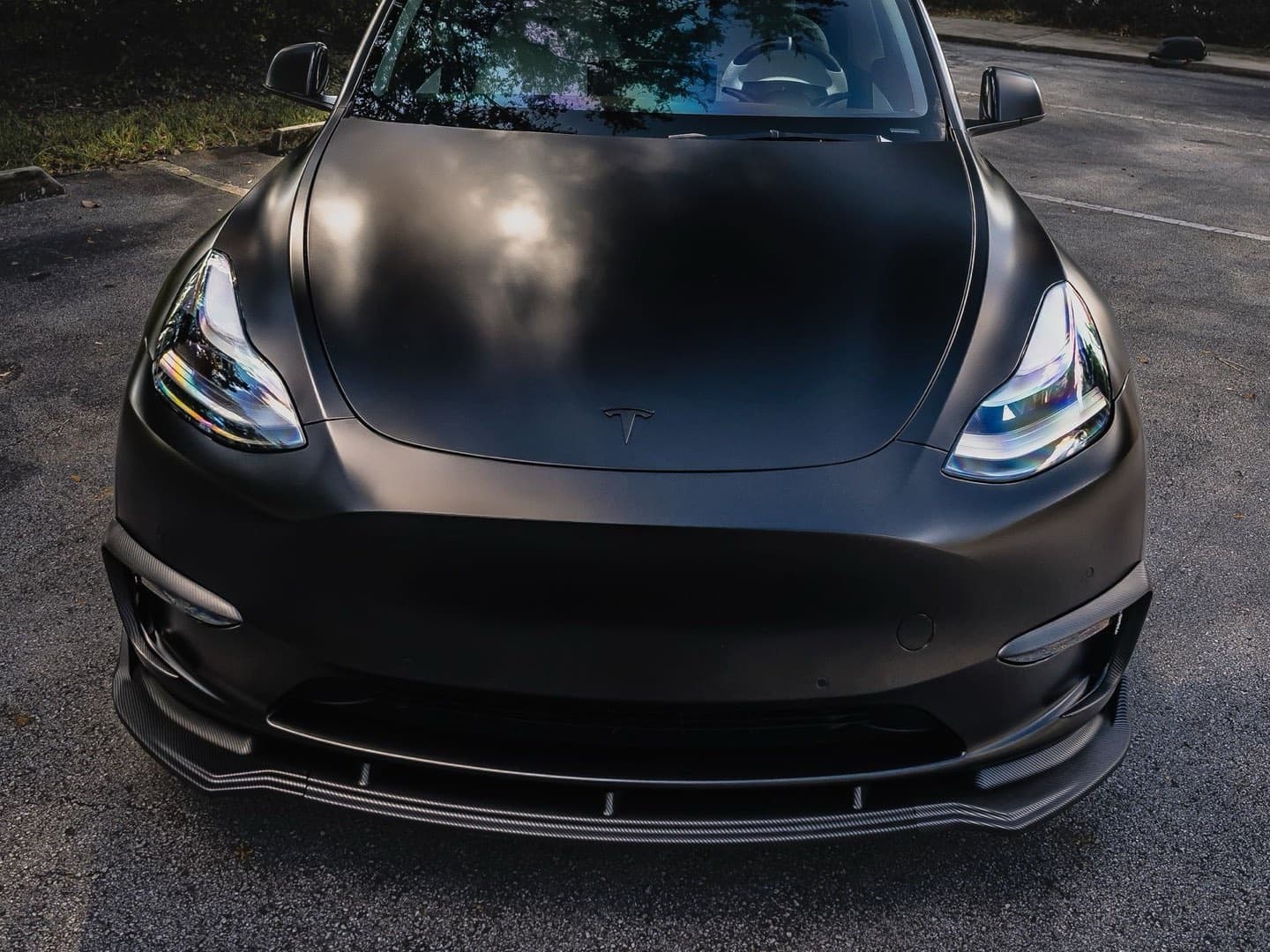 Satin black Tesla Model Y with fully blacked-out trim, badge, and mirrors — the chrome delete look