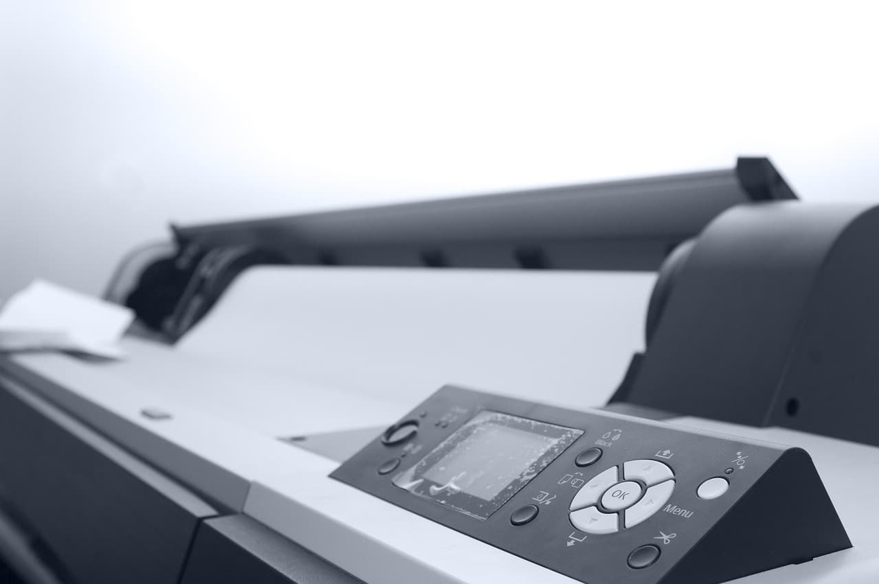 Wide-format inkjet printer with a roll of print media loaded — the class of machine that prints large wall graphics
