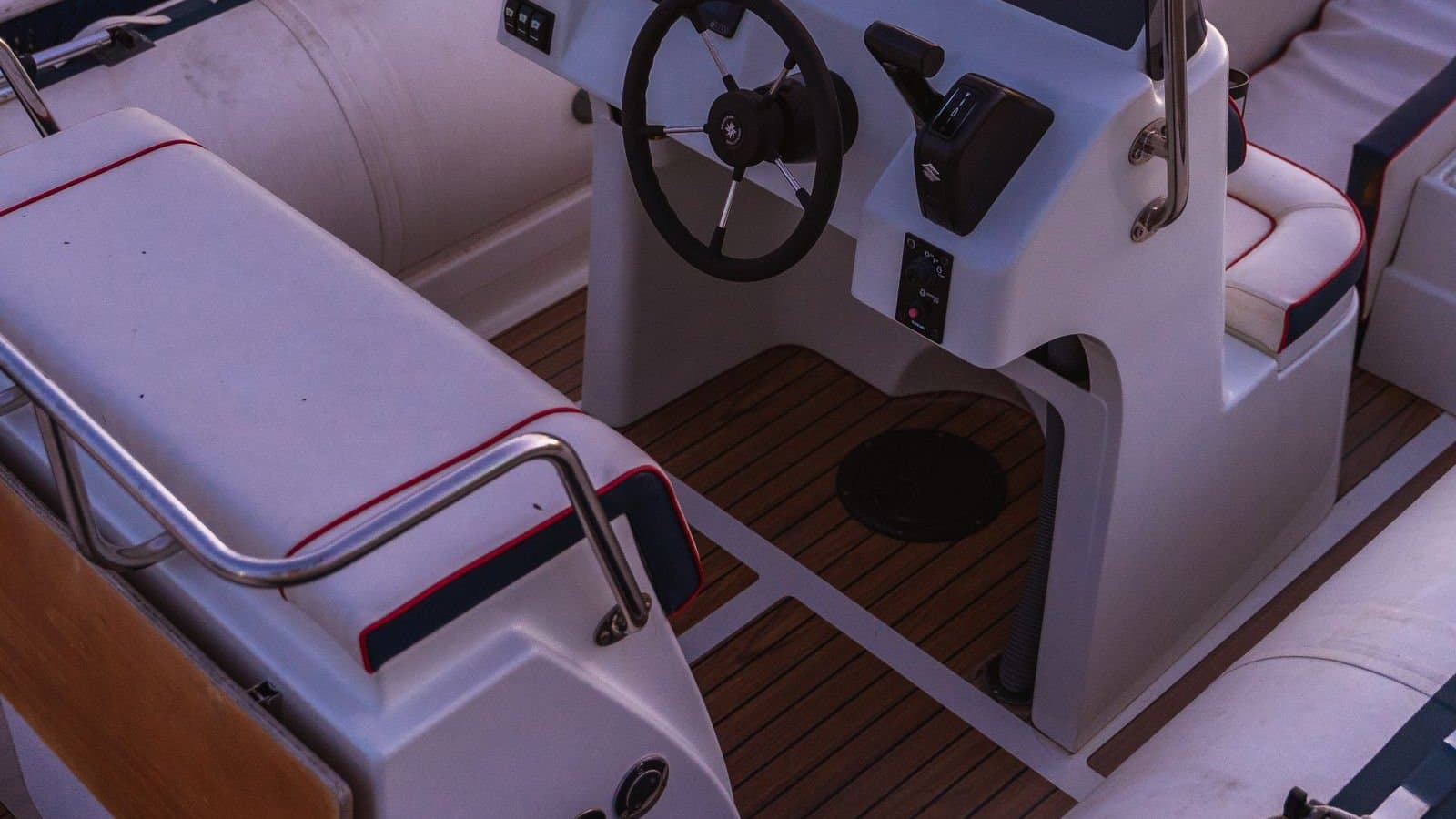 Templated faux-teak decking pads lining the cockpit sole of a rigid-inflatable boat around its center console