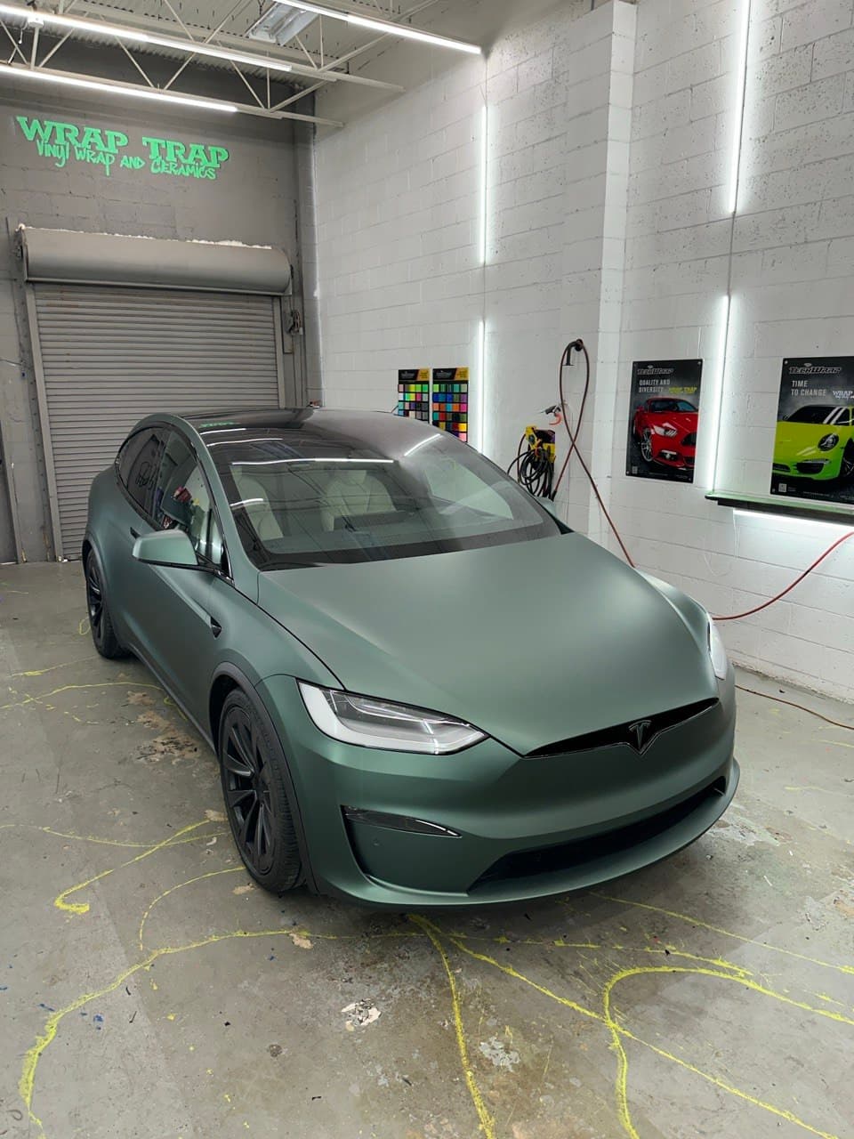 Tesla Model X in matte pine green metallic wrap inside the Wrap Trap install bay