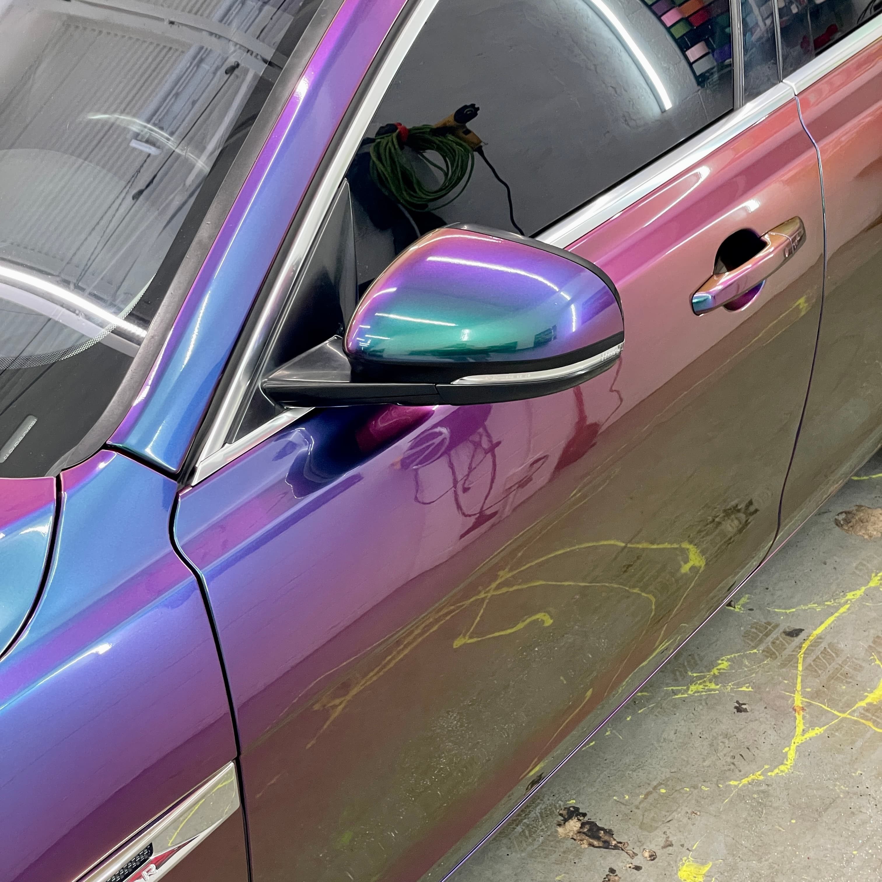 Work in progress at the Wrap Trap shop — color-shift wrap mid-install with our vinyl film wall in the background