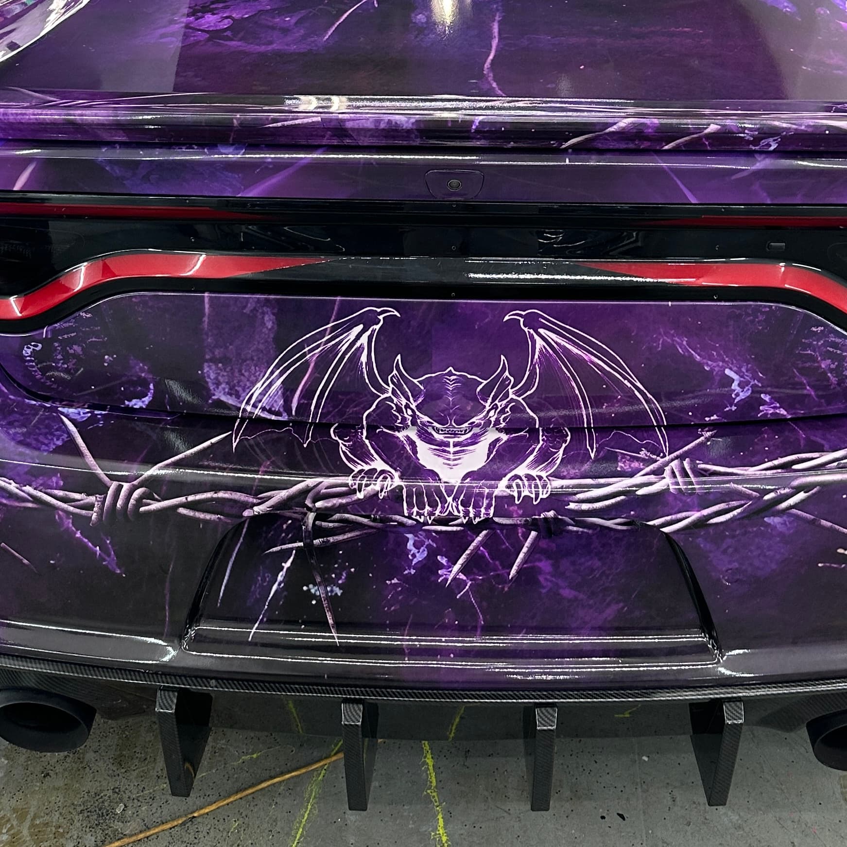 Custom-printed graphic wrap detail on the rear of a Dodge Charger