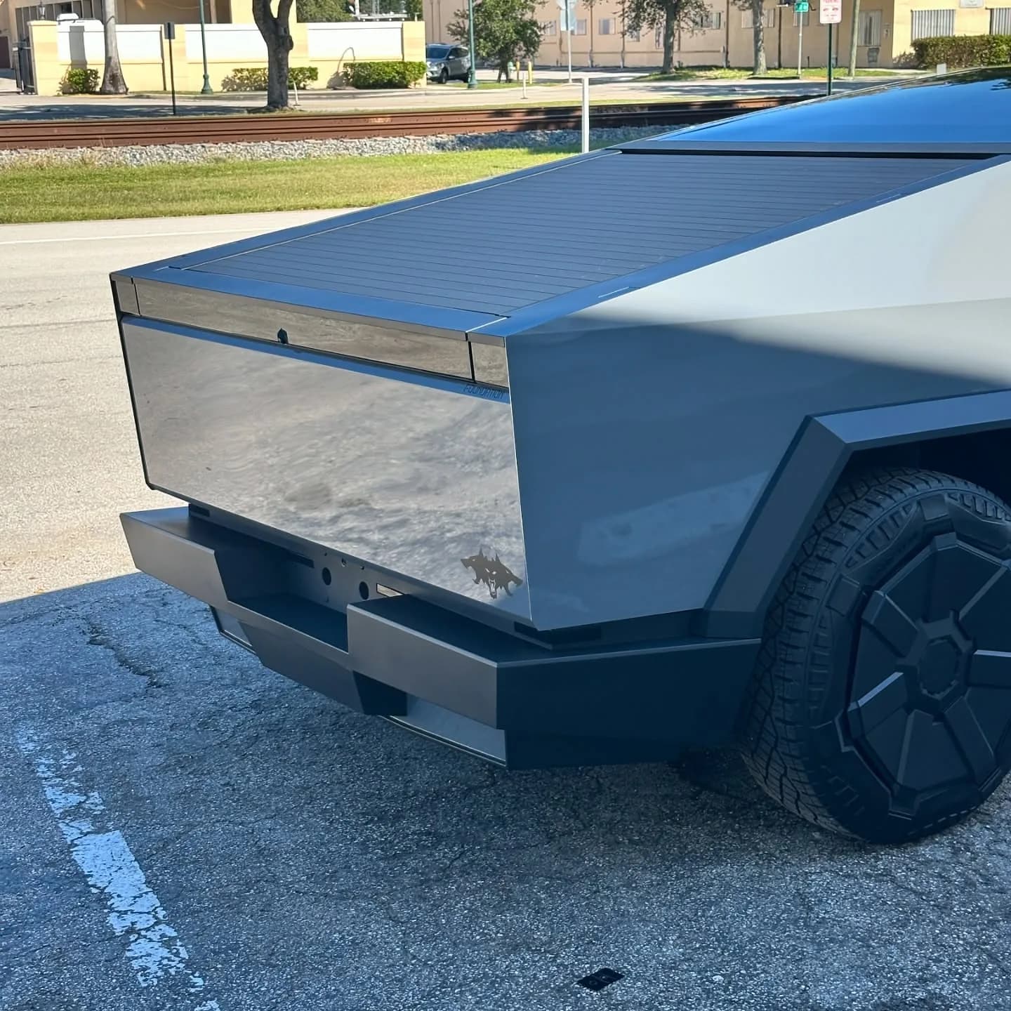 Rear three-quarter view of a wrapped Tesla Cybertruck, tailgate and bed sides
