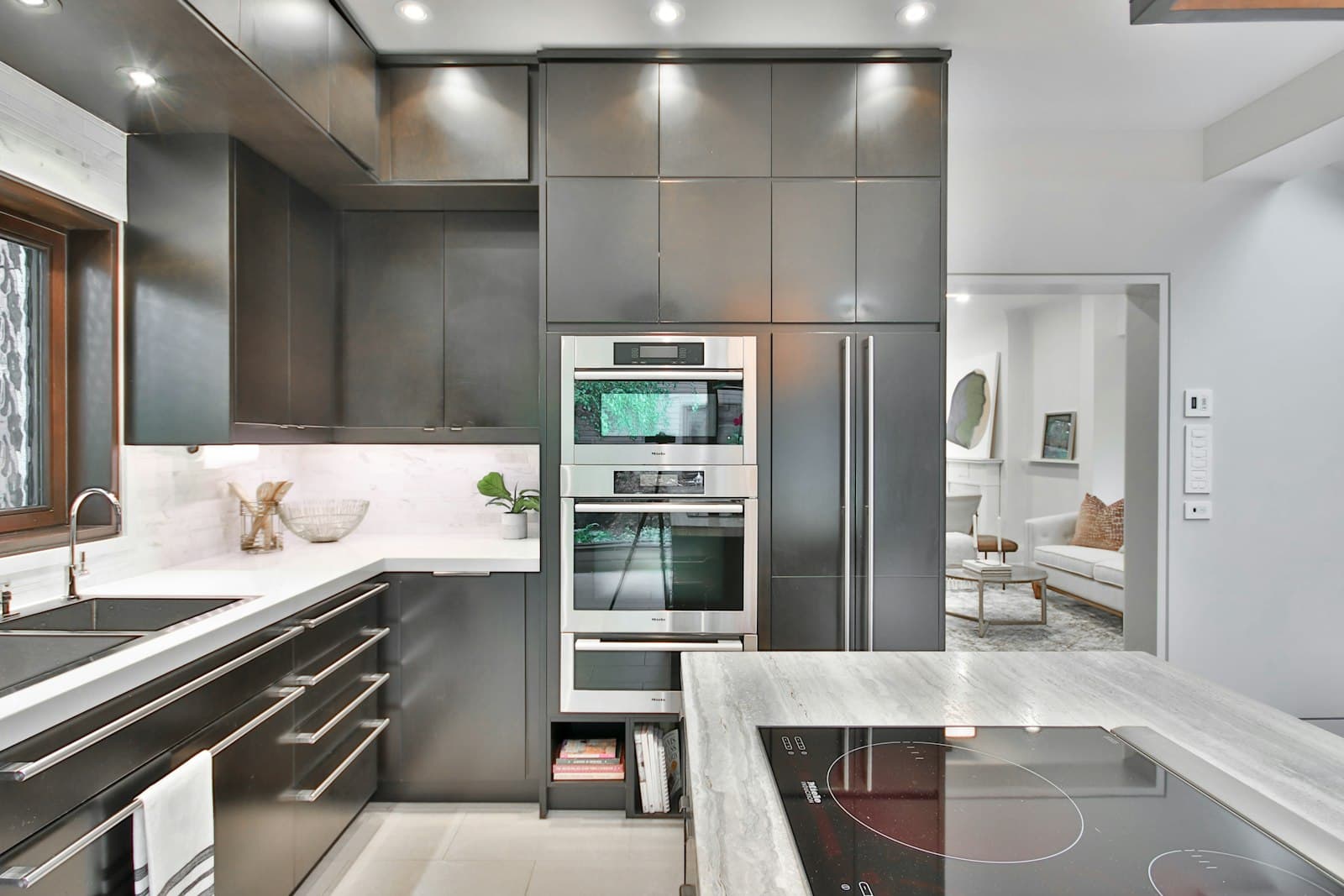Modern kitchen with matte graphite panel fronts, built-in stainless steel ovens and a paneled refrigerator
